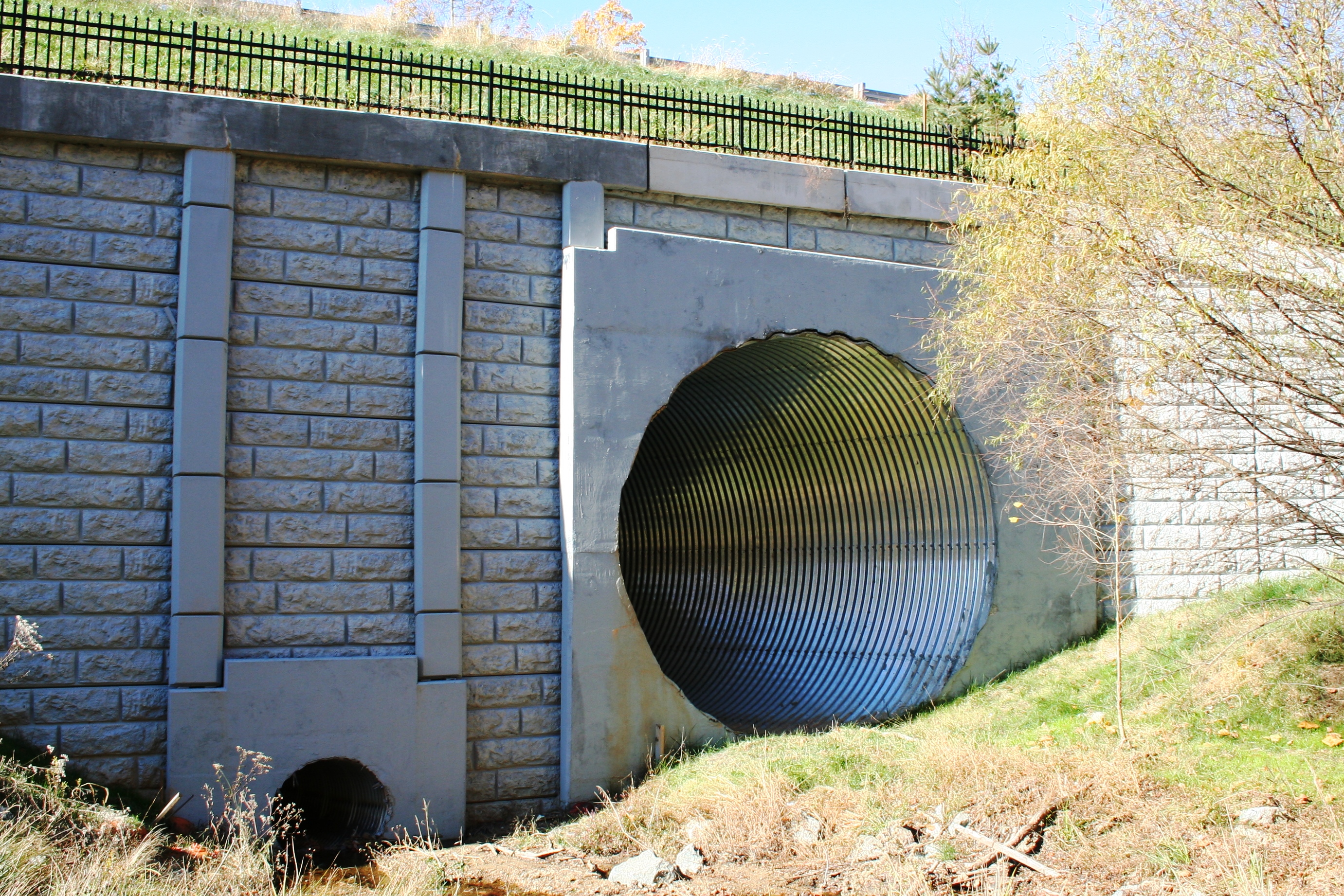 Large metal culvert with low flow concrete culvert with retaining wall in Montgomery County Maryland